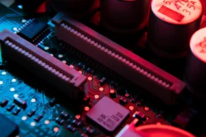 Dois pentes de memória RAM em placa de CPU desktop aberto, iluminados por uma luz colorida, vermelha e azul.