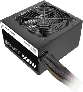 Melhor Fonte Para PC: TOP 8 Melhores Para Comprar em 2024 67 Imagem mostrando a Thermaltake 500 W, que é vista de cima, onde podemos ver o seu ventilador. Na parte traseira ficam os cabos, revestidos em preto com pontas coloridas. E do lado há uma etiqueta preta e branca com informações da fonte. Na parte preta está escrito em letras brancas grandes "SMART 500W". A fonte é preta. O fundo é branco.